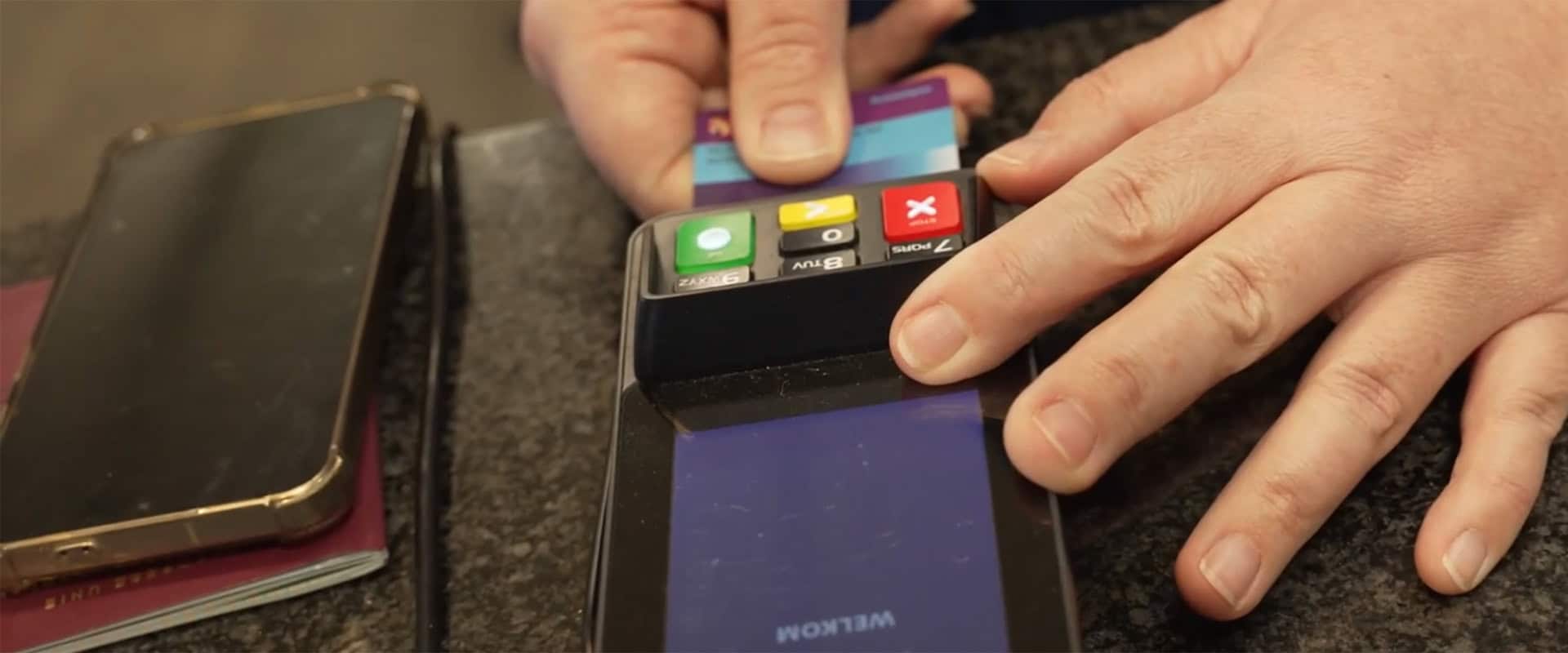 Persoon betaalt met betaalpas via pinapparaat