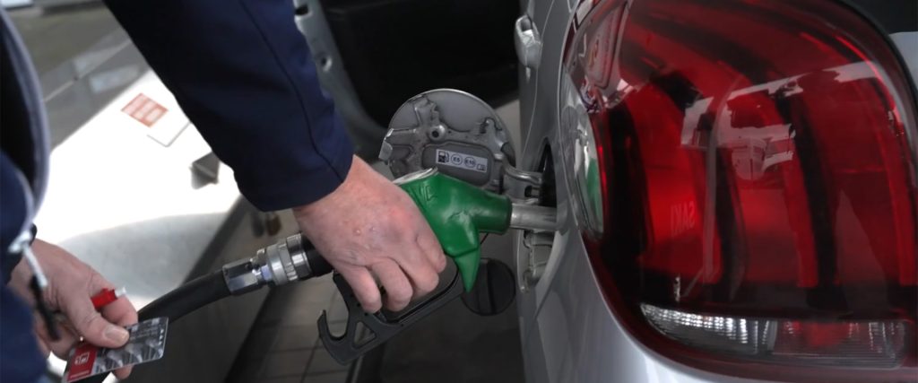 Persoon tankt auto met groene benzinepomp