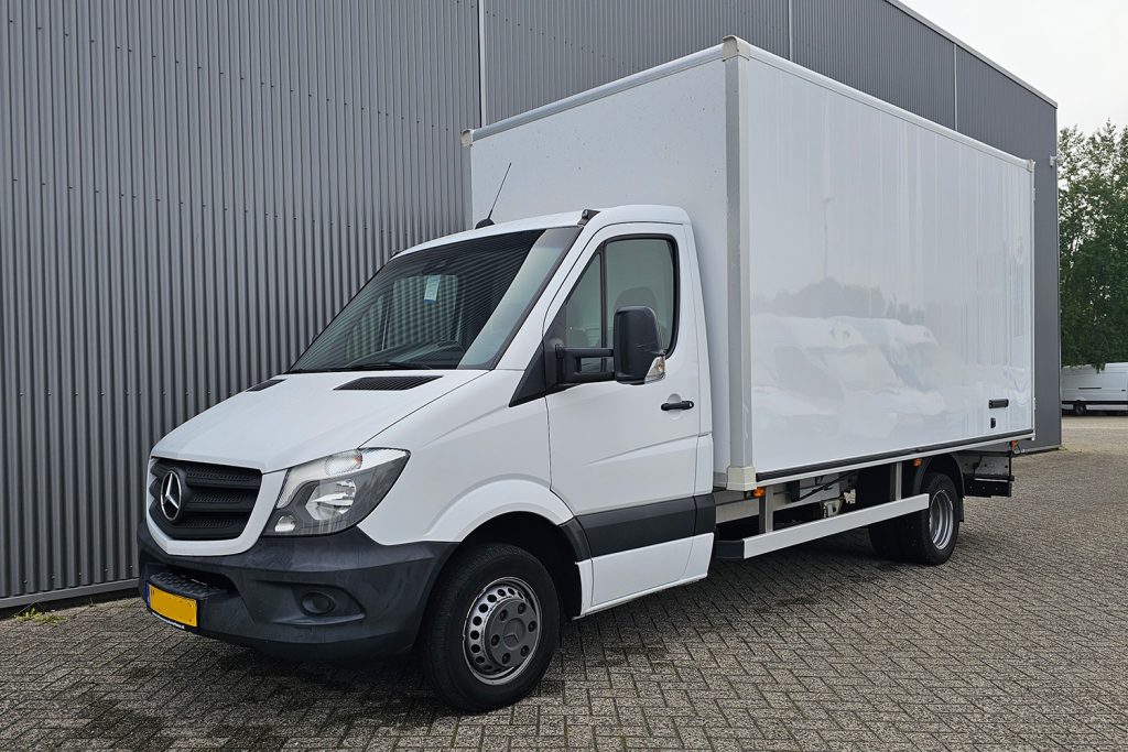 Witte Mercedes-Benz bakwagen geparkeerd naast bedrijfsgebouw