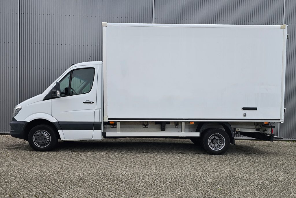 Witte bakwagen geparkeerd naast grijze bedrijfsloods