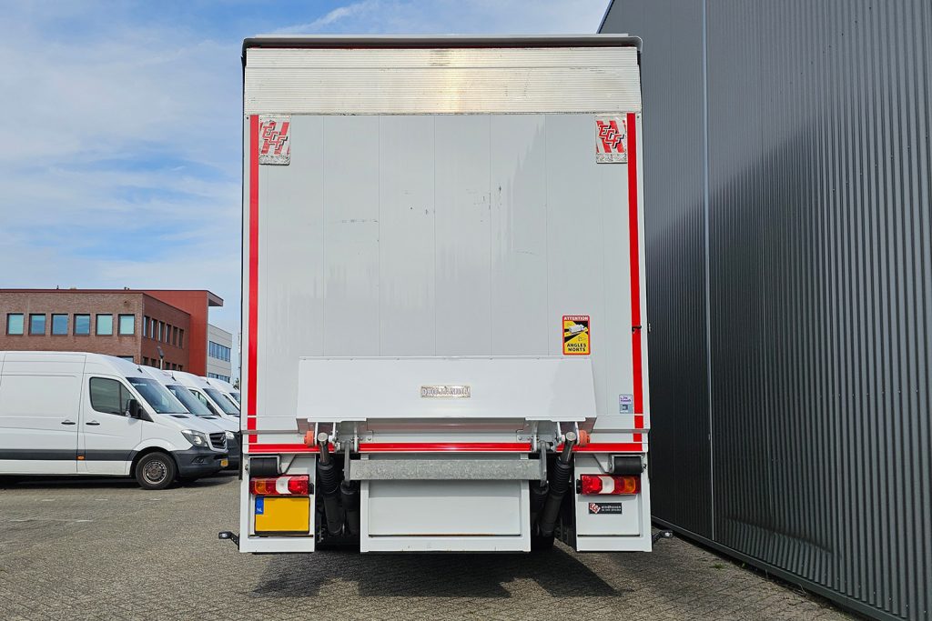 Achterzijde van witte vrachtwagen met laadklep