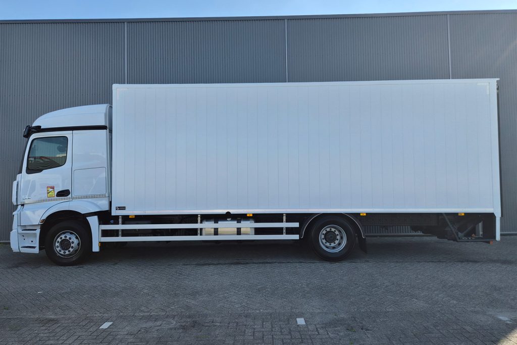 Witte gesloten bakwagen voor een bedrijfsgebouw
