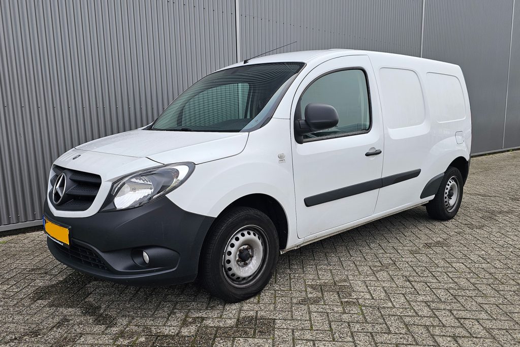 Witte Mercedes-Benz Citan bestelwagen naast metalen wand