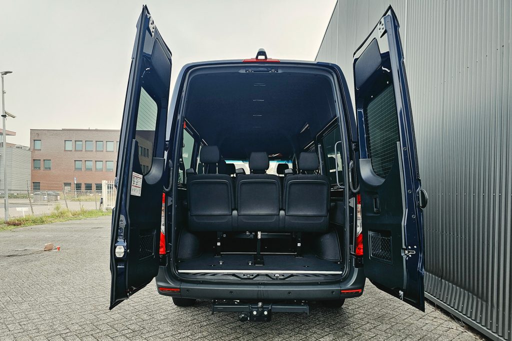Open achterdeuren van donkere personenbus met zitplaatsen