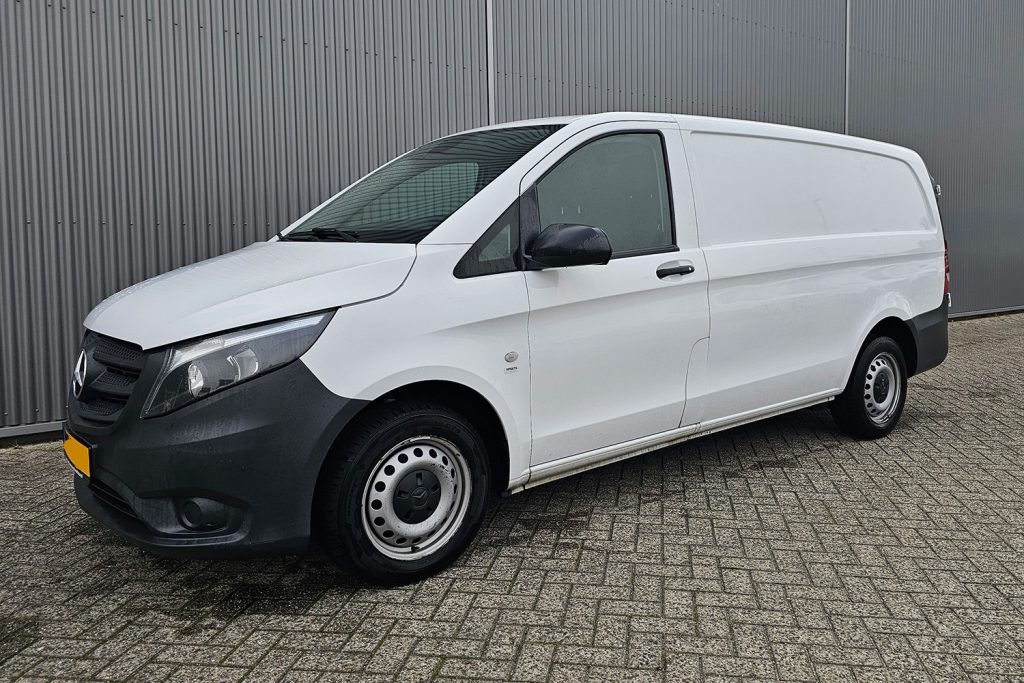 Witte Mercedes-Benz bestelwagen voor grijze metalen wand