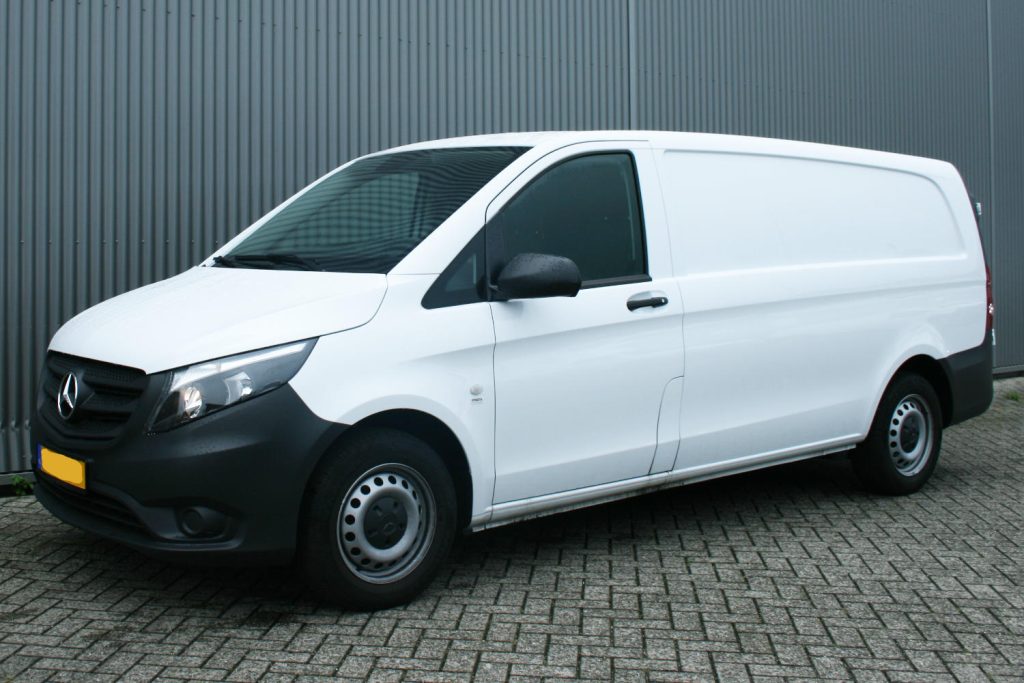 Witte Mercedes-Benz bestelbus voor metalen wand
