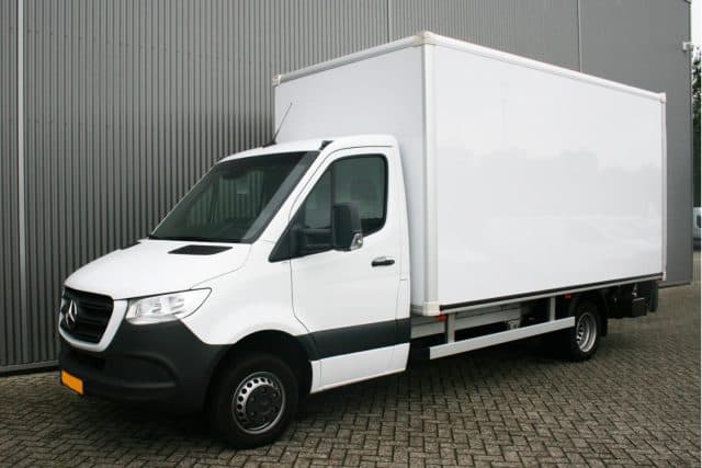Witte Mercedes bestelwagen met gesloten laadbak bij loods