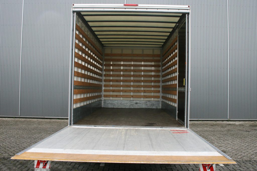 Lege verhuiswagen met open laadklep en houten zijwanden