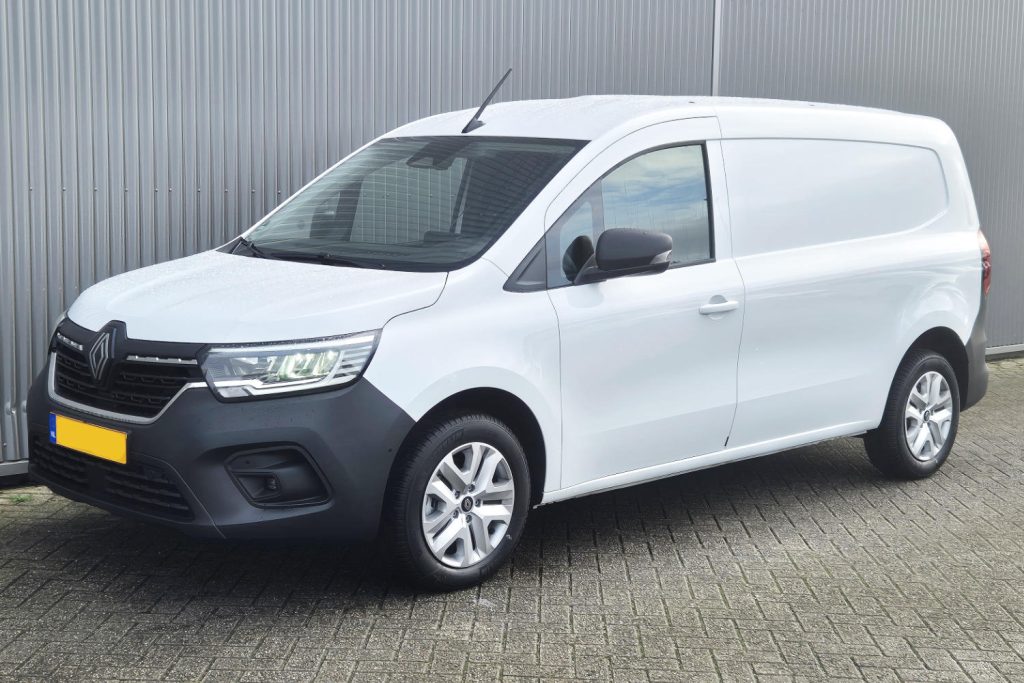 Witte Renault bestelwagen geparkeerd voor metalen wand
