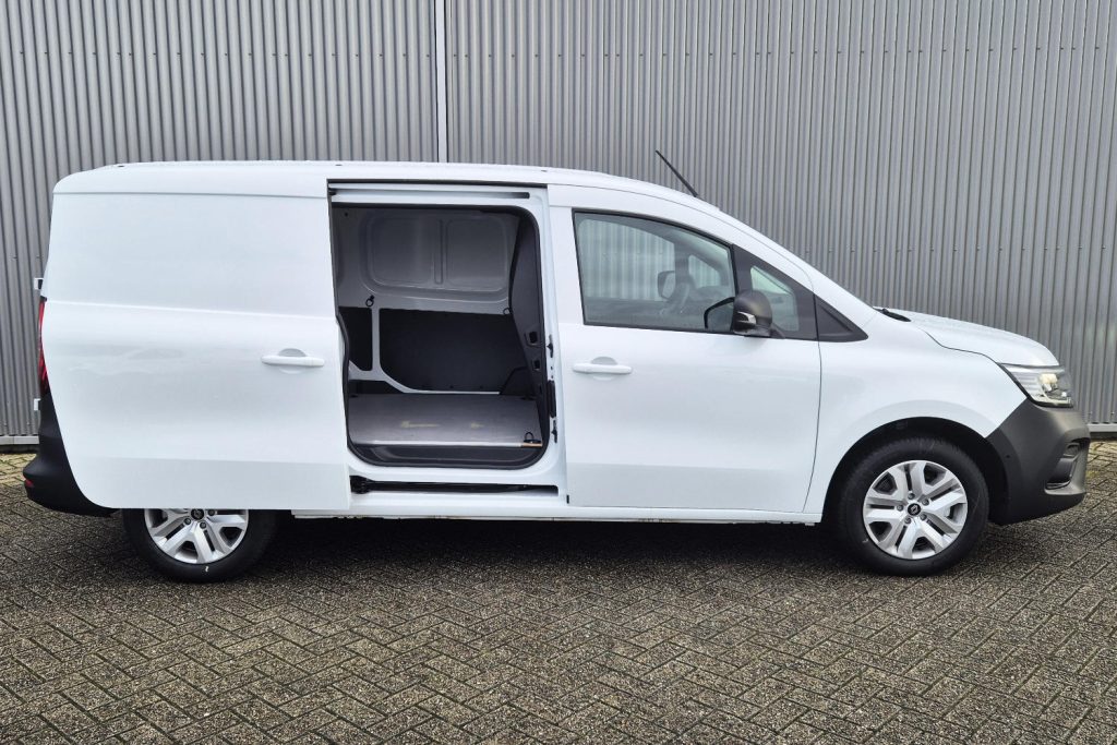 Witte bestelwagen met open schuifdeur naast metalen wand