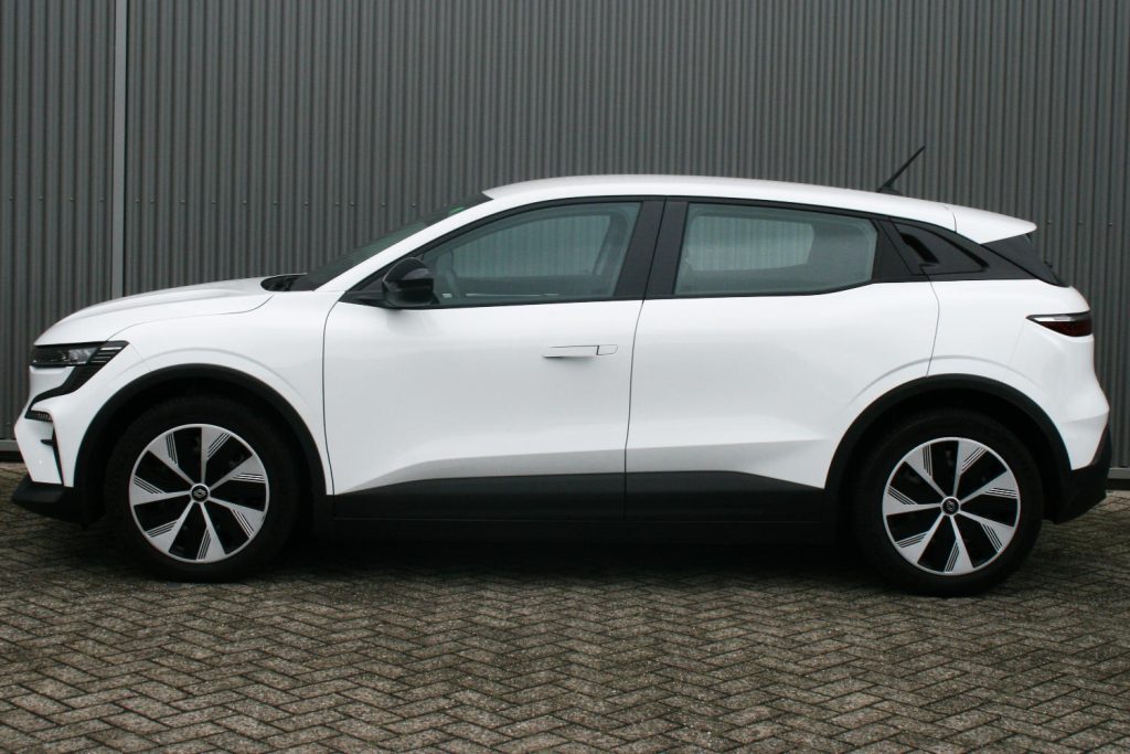 Witte elektrische SUV in zijaanzicht voor metalen wand
