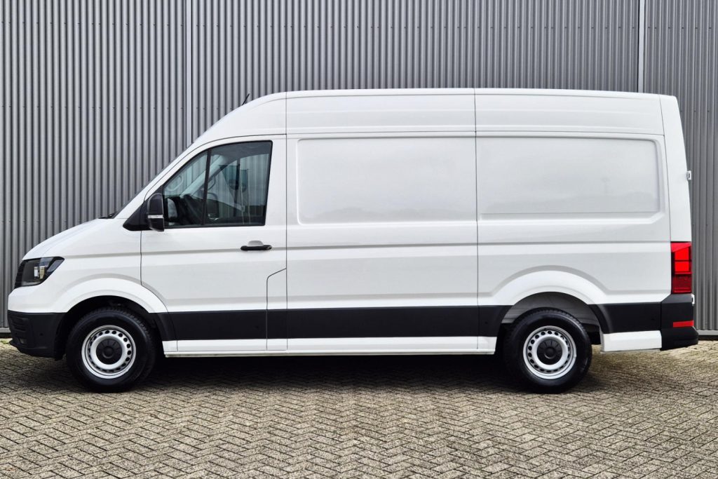 Witte bestelbus geparkeerd voor grijze metalen wand