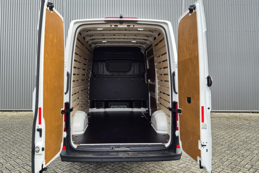 Open achterdeuren van lege witte bestelbus met houten bekleding