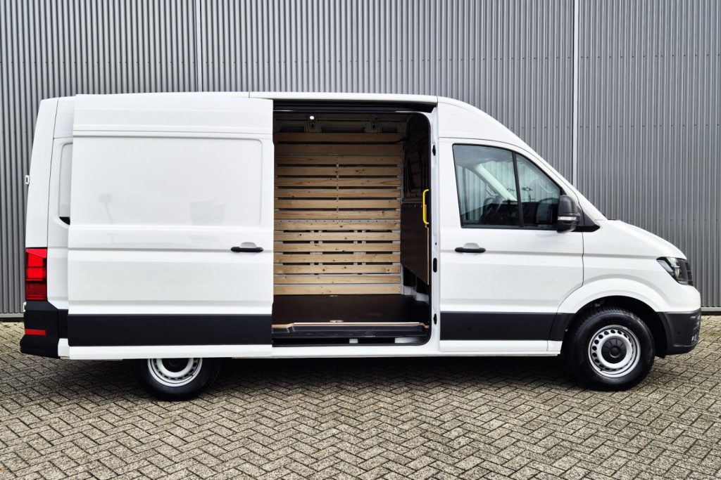 Witte bestelbus met open schuifdeur en houten laadruimte