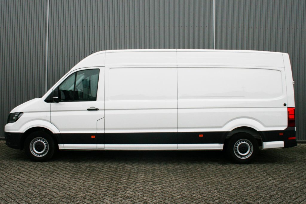 Witte bestelbus geparkeerd voor grijze metalen wand