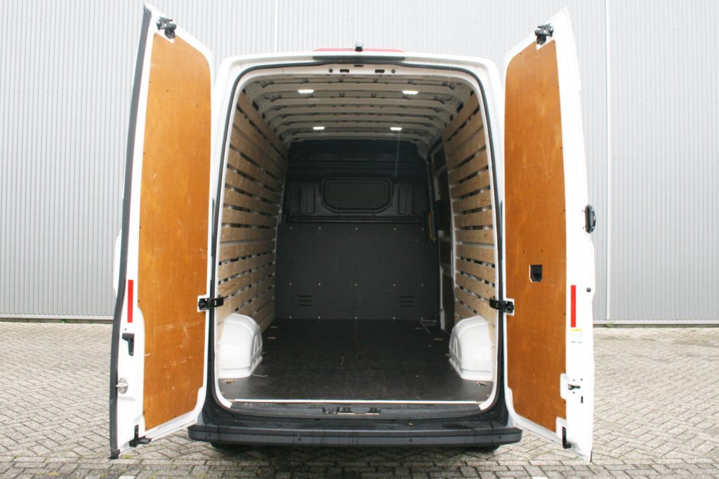 Open laadruimte van witte bestelbus met houten wandpanelen