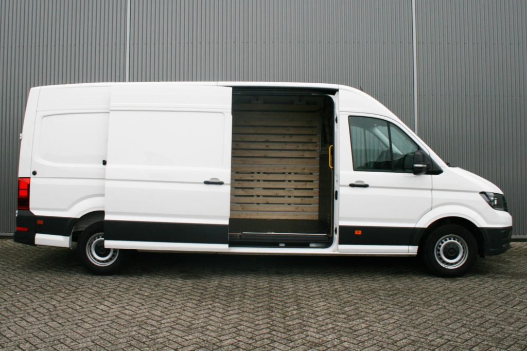 Witte bestelbus met open schuifdeur en houten interieur
