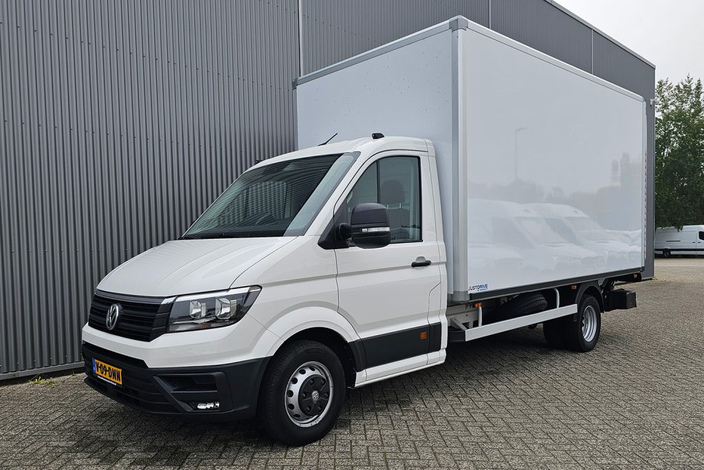 Witte Volkswagen bakwagen geparkeerd bij bedrijfsgebouw