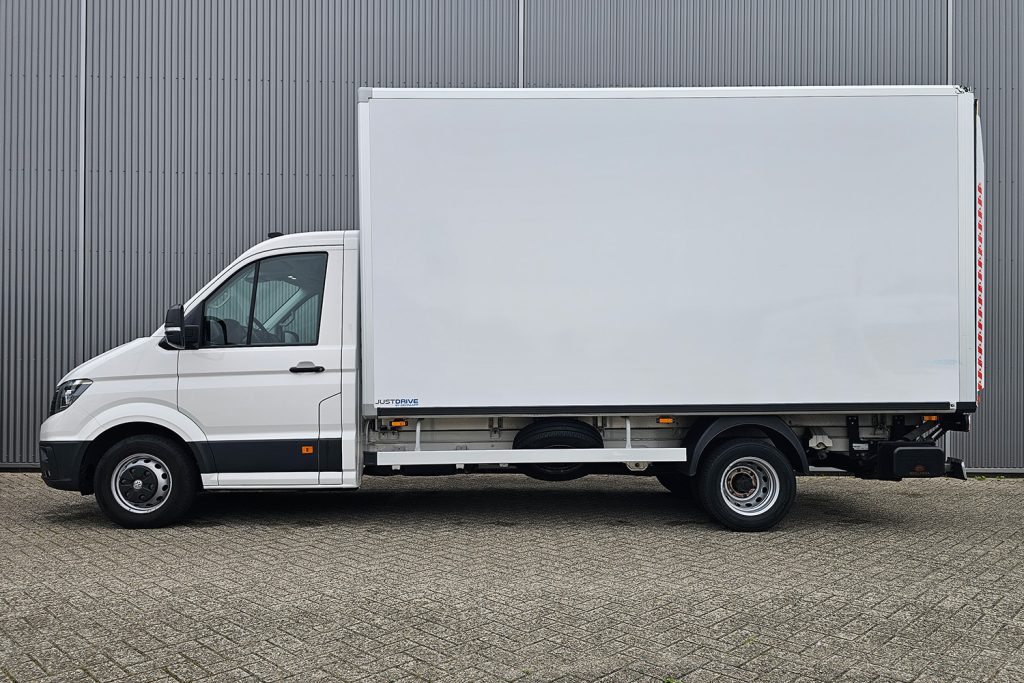 Witte bakwagen geparkeerd voor grijze metalen gevel