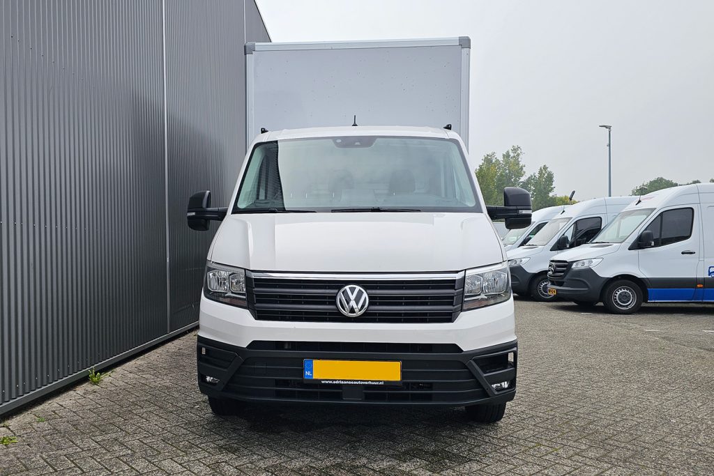 Witte Volkswagen bakwagen geparkeerd bij bedrijfsgebouw