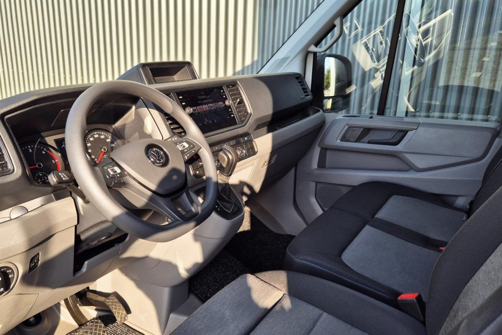 Interieur van Volkswagen bestelwagen met stuur, dashboard en passagiersstoel